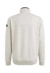Sweatshirt gris clair avec un col montant, des poignets et un ourlet côtelés, une finition texturée et une étiquette d'accent noir sur la manche gauche.