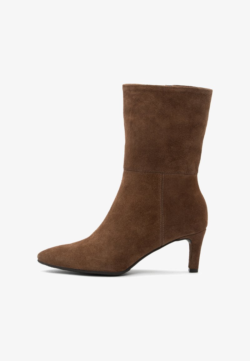 Botas de tobillo de ante marrón con punta afilada, tacón de aguja delgado y textura suave; presentan costuras laterales y un diseño cónico.