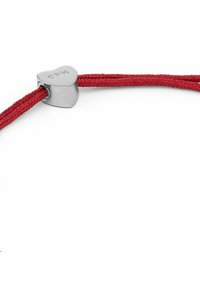 Rotes geflochtenes Schnurarmband mit einem herzförmigen Silberverschluss, der eingravierte Details aufweist. Die glatte Textur und die kontrastierenden Farben sind prägnant.