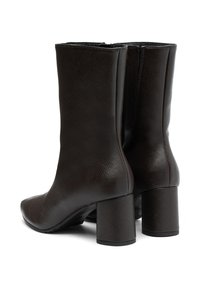 Botas de tobillo de cuero marrón con un acabado texturizado, punteras redondeadas y tacones cuadrados, que cuentan con un cierre de cremallera en la parte trasera.