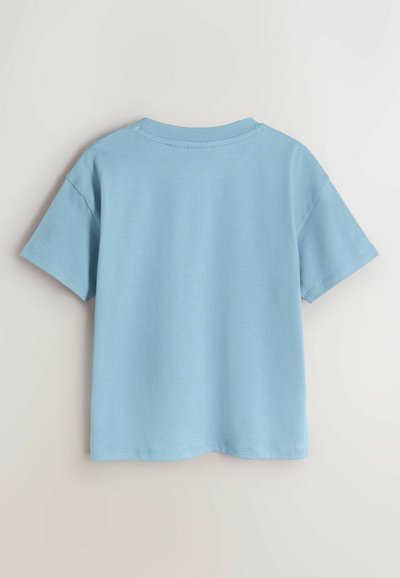 T-shirt en coton bleu clair avec col rond, manches courtes et coupe décontractée. Texture lisse avec ourlet cousu.