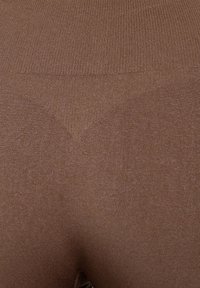 Leggings marroni in maglia con una texture morbida e una finitura liscia. La vita è elastica e il design complessivo è aderente.