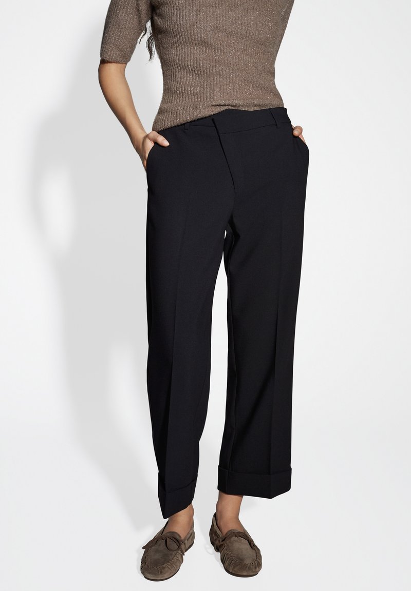 Black trousers with a tailored fit, featuring side pockets, sharp crease, and turned-up cuffs. Smooth fabric with a polished finish.