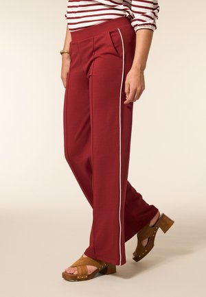 Bordeaux wijde broek met witte zijkanten, voorzien van voorplooien en een zachte textuur, gecombineerd met tan blokhak sandalen.