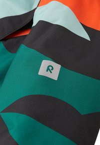 Tessuto multicolore con onde di teal, nero e arancione; include un distintivo grigio con un "R" stilizzato. Texture liscia.