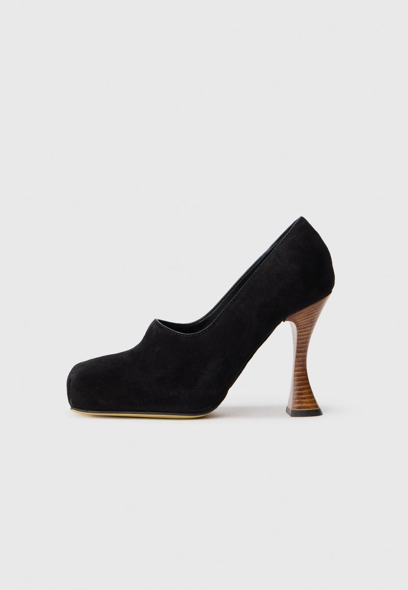Pantof cu toc înalt din suede negru, cu vârf rotunjit, toc din lemn curbat și textură netedă, mată. Design minimalist, fără embellishe.