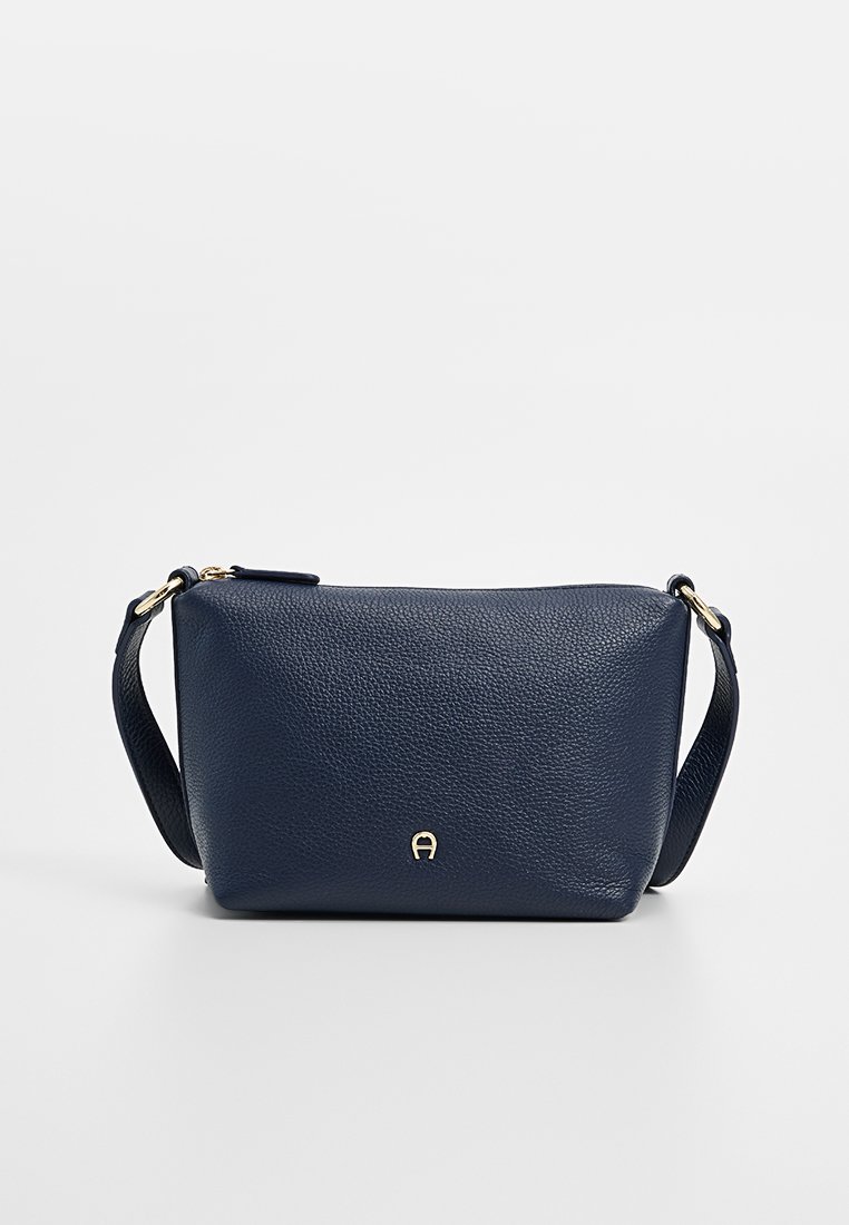 Marineblaue Leder-Umhängetasche mit strukturiertem Finish, goldfarbenem Logo-Akzent und verstellbarem Tragegurt. Rechteckige Form mit Reißverschluss.