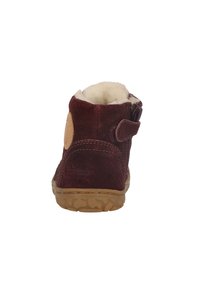 Hnědé semišové kotníkové boty s měkkou vnitřní podšívkou, bočním zipem a texturovanou gumovou podrážkou. Na vnější straně paty se nachází kulaté logo.