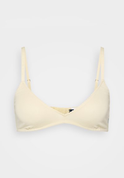 Light beige bralette with a triangular design, adjustable straps, and scalloped edging. Soft fabric with no padding.