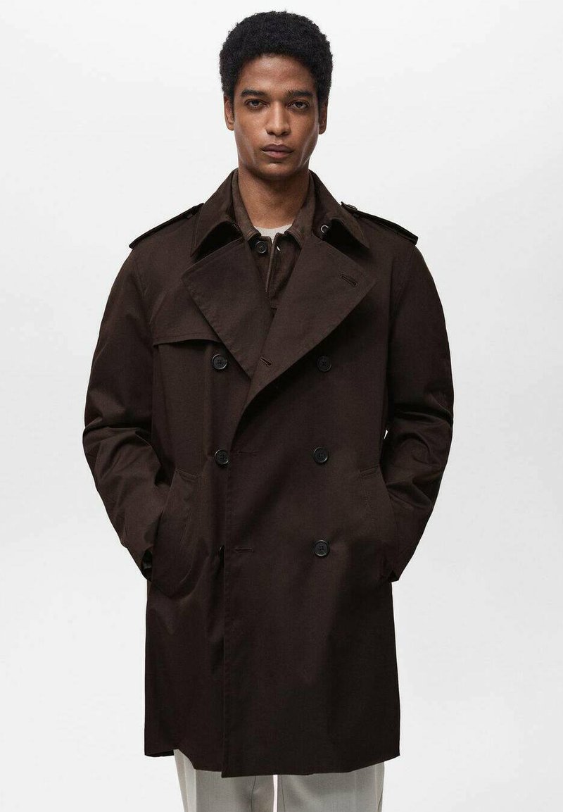 Bruine dubbelbreasted trenchcoat met een brede revers, schouderepauletten en voorzakken, gemaakt van een gladde stof.