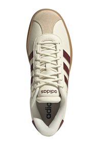 Sneaker bianca con strisce e dettagli bordeaux, caratterizzata da un design con lacci, punta in suede e suola in gomma. Logo sulla linguetta.