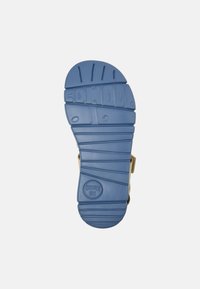 Podeszwa sandała w niebieskiej gumie z teksturowanym wzorem zapewniającym przyczepność. Zawiera wytłoczoną nazwę marki i okrągłe logo. Widoczne punkty mocowania pasków.