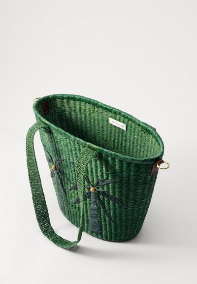 Cesto intrecciato verde con una finitura testurizzata, caratterizzato da una forma rotonda, manico intrecciato e decorazioni a foglia ricamate. Dettagli in hardware dorato visibili.