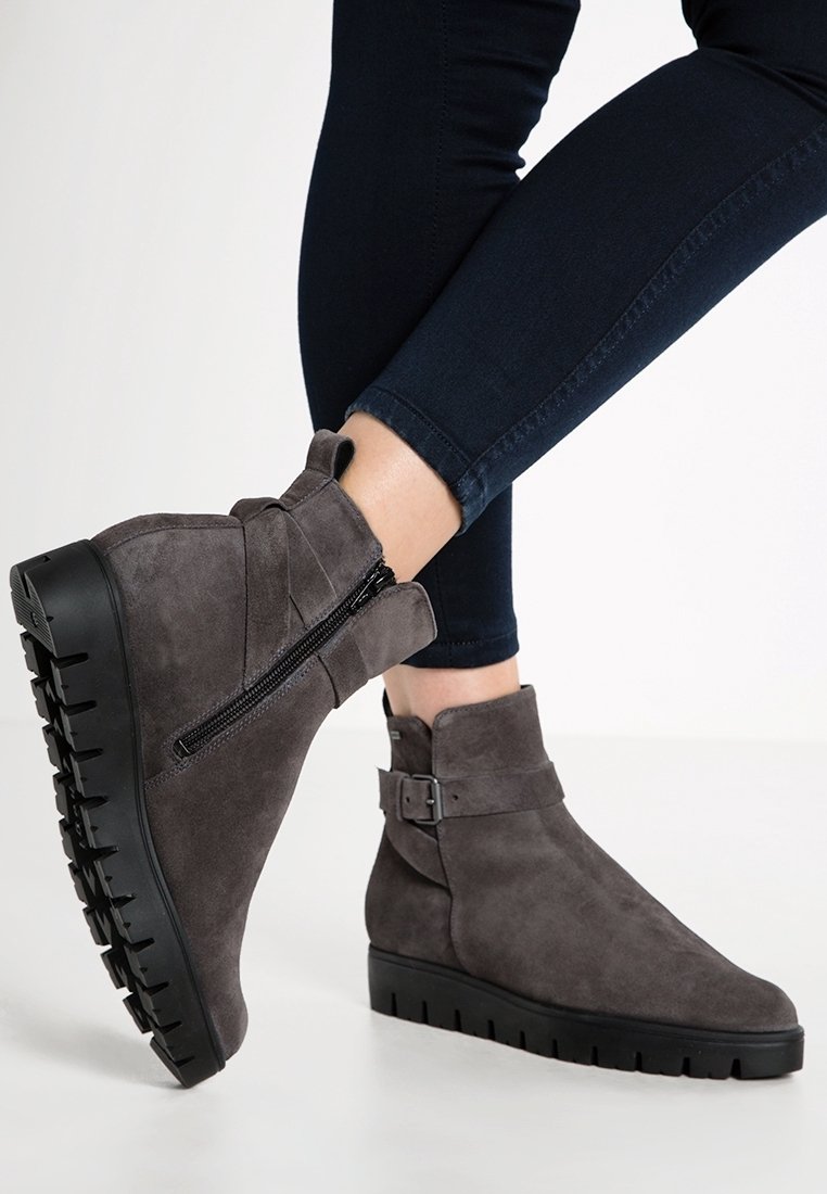 Bottines en daim gris avec une fermeture éclair sur le côté, accent de boucle et une épaisse semelle noire; design épuré et matériau texturé.
