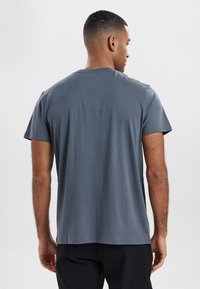 Grå t-shirt med kortærmer og rund hals, lavet af blødt stof, med en glat overflade og en afslappet pasform. Ingen synlige mønstre.