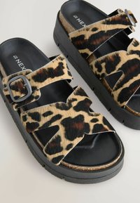 Sandalen met een luipaardprint, voorzien van twee dikke banden en een gesp, gemaakt van nep-bontmateriaal, met een kurken voetbed en een dikke zwarte rubberen zool.