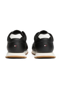 Sneaker nere con accenti bianchi e finitura testurizzata, dotate di suola in gomma. Dettaglio del logo ben visibile sul tallone.