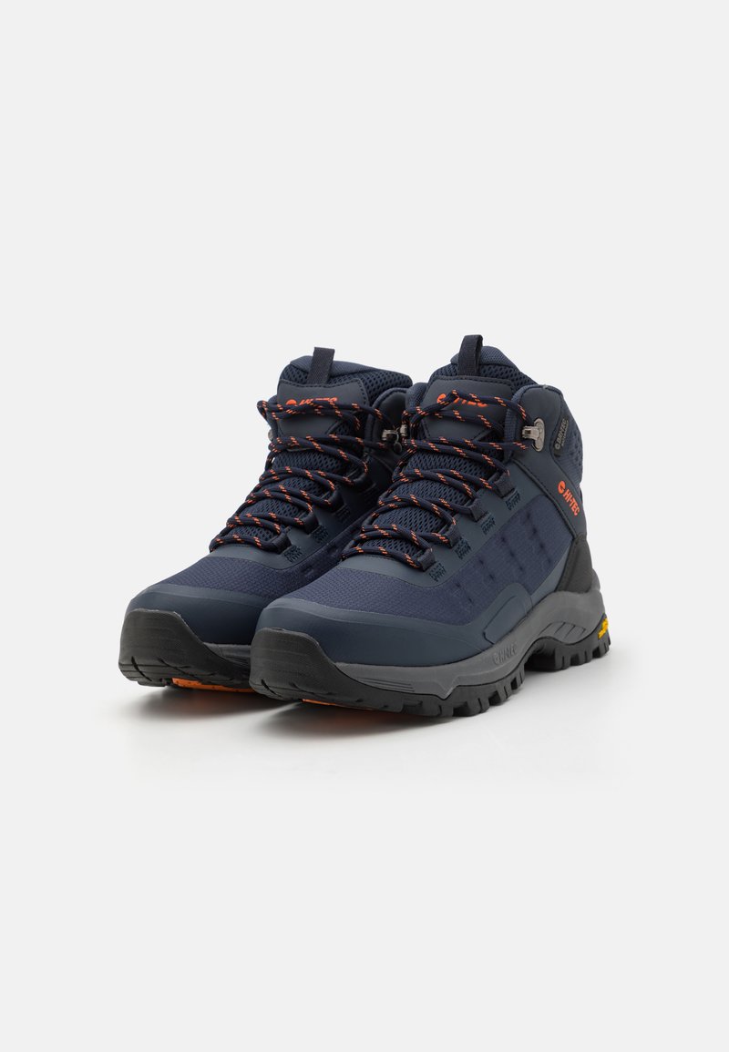 Scarpe da trekking blu navy con lacci arancioni, parte superiore in mesh e materiale sintetico, collo imbottito e suola in gomma resistente con scolpitura pronunciata.