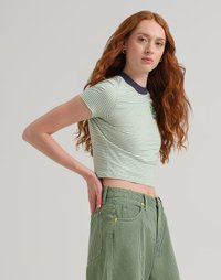 T-shirt cropped a righe verdi e bianche con colletto blu navy e dettagli con logo, abbinato a pantaloni a vita alta a righe verdi.