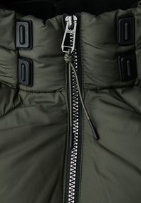 Zelená péřová bunda s předním zipem, silným vycpáním a černými akcenty. Obsahuje stahovací šňůrku u límce a patentní knoflíky.