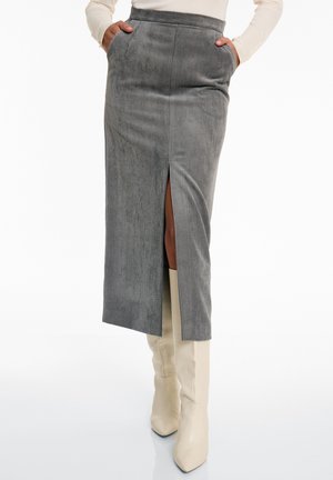 Grijze corduroy midi-rok met een zijsplit, beschikt over voorkanten en een aansluitende tailleband. Gepaard met crèmekleurige laarzen tot de knie.