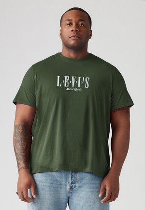 Olive green cotton t-shirt featuring a white Levi's logo print. Short sleeves and crew neckline, worn with light blue jeans.