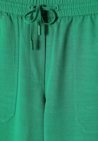 Groene katoenen sweatpants met een elastische tailleband en een trekkoord, twee zijzakken en een gestructureerde stof voor comfort.