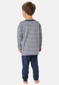 Langärmliges gestreiftes Shirt in Grau und Marineblau mit Rundhalsausschnitt, kombiniert mit marineblauen Hosen. Weicher Stoff, lockere Passform und Knöchelbündchen an den Hosen.