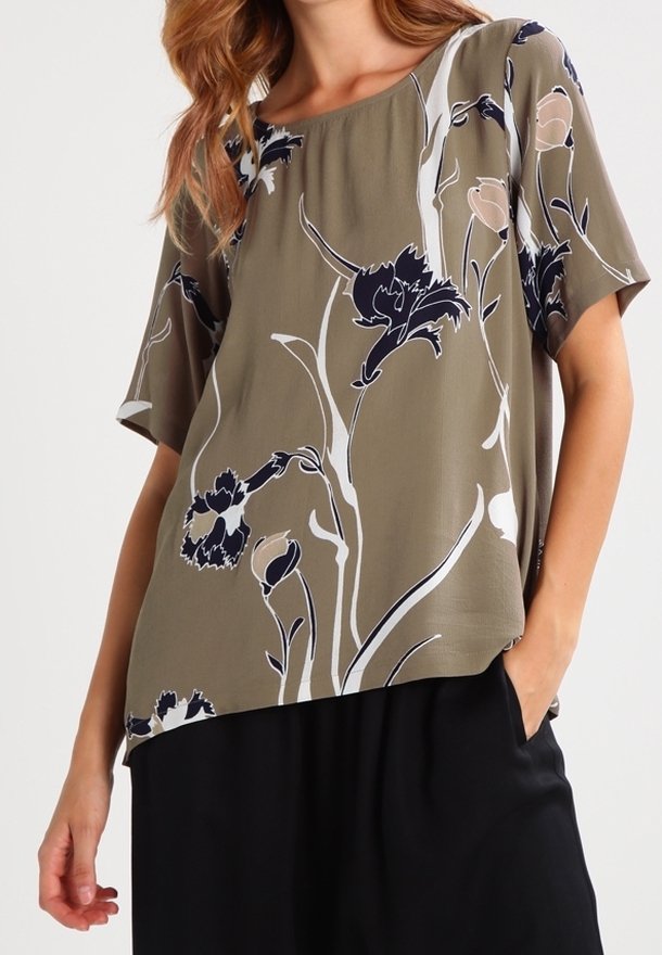 Olivengrøn kortærmet bluse med et blomsterprint i marineblå og creme, med en afslappet pasform og rundet kant, lavet af et let stof.