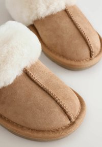 Ruske suede tohvelit, mille sisemus on pehmeast kreemivärvi karvast. Omab tikandiga kujundust ja tekstureeritud tallad, mis tagavad haarde.