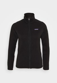 Svart fleecejacka med hel dragkedja från Patagonia, med hög krage, långa ärmar och logotyp på vänster bröst mot en enfärgad bakgrund.