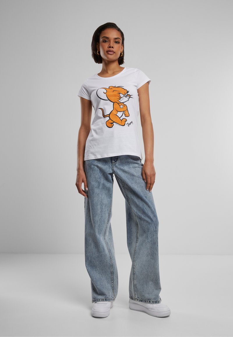 T-shirt en coton blanc avec un design de personnage de dessin animé orange. Associé à un jean large bleu clair et des baskets blanches.