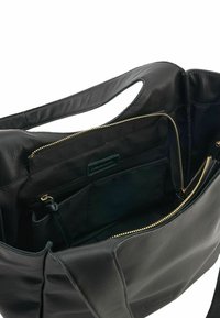 Borsa a tote nera in pelle con una texture liscia, dotata di cerniere dorate e un ampio interno con diversi scomparti per l'organizzazione.