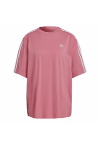 Růžové oversized tričko z bavlny, které má krátké rukávy, kulatý výstřih a bílé pruhy na ramenech s malým logem.