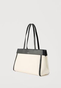 Μπεζ ορθογώνια τσάντα χειρός με μαύρο δερμάτινο περίγραμμα και διπλές λαβές, εμφανίζεται σε απλό ανοιχτό φόντο.