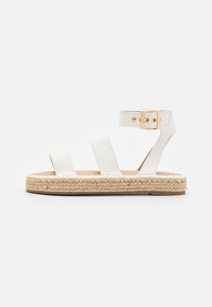 Hvide lædersandaler med tre brede remme, ankelspænde og sål indpakket i jute. Fladt design med en glat tekstur.