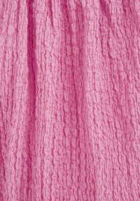 Tessuto di colore rosa chiaro con una superficie rugosa caratterizzata da scanalature verticali e motivi irregolari. Materiale morbido dall'aspetto leggero.