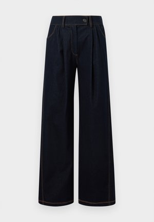 Pantalon large bleu foncé avec plis à l'avant, passants pour ceinture, poches latérales et surpiqûres contrastantes sur fond blanc.
