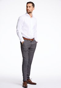 Witte button-up blouse, grijs geblokte broek, bruine leren riem en bijpassende schoenen. Moderne pasvorm, gladde stof, op maat gemaakt ontwerp.