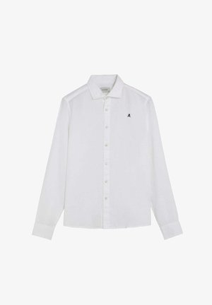 Camisa blanca de manga larga con botones, cuello y pequeño logo negro de calavera y huesos cruzados en el pecho izquierdo.