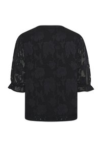 Melnā blūze ar caurspīdīgām garām piedurknēm. Ar teksturētu ziedu rakstu un volāna apdari piedurkņu galā. Vienkārša apaļa izgriezte.