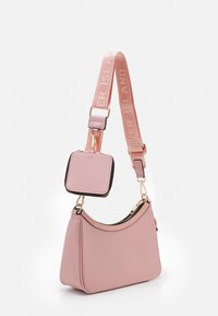 Różowa torebka na ramię z szerokim, regulowanym paskiem, z napisem "River Island" oraz dołączoną małą kwadratową saszetką na monety z zamkiem błyskawicznym.