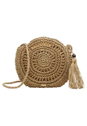 Ronde geweven stro kruisbodytas met spiraalpatroon, gevlochten riem en lange kwast met een houten kraal op een witte achtergrond.
