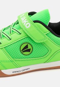 Žalias sportinis batas su tinkliniu ir sintetine oda. Ypatybės: Velcro dirželis, logotipas ir guminis padas su užrašu "PRO-GRIP".