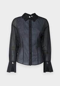 Blusa nera trasparente con righe verticali bianche, colletto classico, apertura frontale con bottoni e maniche svasate. Tessuto liscio con una leggera lucentezza.