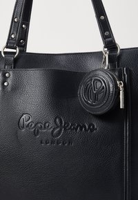 Juodas odinis tote krepšys su iškilmingu „Pepe Jeans London“ logotipu, metaliniais akcentais ir pridedamu apvaliu užtraukiamu pouches.