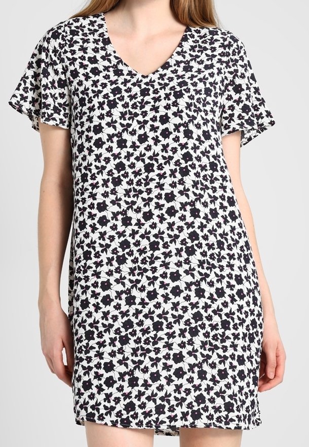 V-pääntie lyhythihainen mekko valkoisena, jossa on kukkakuosi tumman violetin ja mustien kukkien kanssa. Kevyt, valuva kangas rentoa istuvuutta varten.