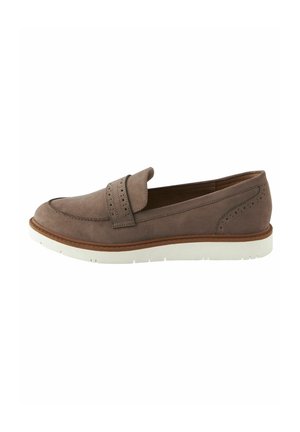 Chaussure slip-on en suede marron avec un détail de strap perforé, bout rond, semelle en caoutchouc blanc et accents de coutures le long des bords.