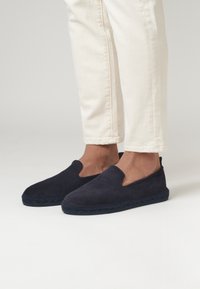 Zapatillas náuticas de gamuza en color azul marino con suela de yute trenzado. Con puntera redonda y textura suave, el diseño no presenta cierres.