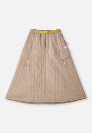 Béžová prešívaná sukňa s rozšíreným strihom, bočnými vreckami a kontrastným žltým opaskom. V hornej pravej časti sa nachádza logo.